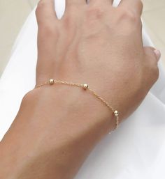 "Simple. Chic. Minimalist™ A perfectly dainty, lightweight, most feminine gold filled bracelet. This bracelet is made with 14k gold filled dots measure 3mm each and 14K gold filled chain, personalized with a tiny 14K gold plated initial and wire wrapped pearl for an extra classy look. Also can be wear as an anklet- simply choose large size at checkout. 〰 All parts are made with top quality materials! Also available with sterling silver or 14K Rose gold filled Model is wearing 6.5\" length This b Minimalist Everyday Beaded Bracelet With Delicate Chain, Minimalist Hypoallergenic 14k Gold Filled Bracelets, Minimalist Hypoallergenic 14k Gold-filled Bracelets, Dainty 14k Gold Beaded Bracelets, Dainty Yellow Gold Hypoallergenic Beaded Bracelets, Adjustable Minimalist Gold Bracelet With Satellite Chain, Minimalist 14k Gold Filled Beaded Bracelets For Everyday, Delicate 14k Gold-filled Bracelets With Gold Beads, Minimalist Beaded Bracelets With Satellite Chain For Everyday