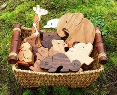 a basket filled with wooden animals on top of green grass