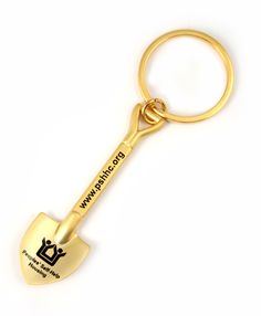 a gold keychain with a shovel shaped like it is holding the word wwp