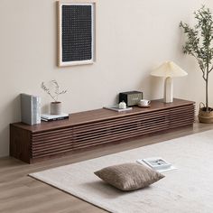 a living room with a white rug and wooden furniture