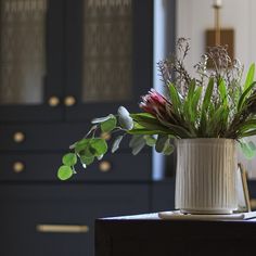 a vase with some flowers in it sitting on a table