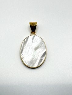 Charles Albert Designer Mother of Pearl White Oval Pendant is Bezel set in their Signature Alchemia Gold.  A Lovely White color in this Cultured Mother of Pearl Cabochon pendant .  Pendant is open on the back revealing a lovely mother of pearl coloring.  This lovely Pendant is a Charles Albert White Mother of Pearl Oval Pendant set in Alchemia Gold  and signed by the designer 'Charles Albert' inside of the bail.  Pendant hangs 2.25 inches from the top of the bail.  Pendant itself is 1.6 x 1.25 Inch Oval Shape.  Really pretty pendant for any Pearl lover!  Pearl is the June Birthstone!  Charles Albert Gold Tone Paperclip Chain not included in price of the pendant, but available in variations in 18, 24, 30 and 36 inch lengths. A Charles Albert Designer Mother of Pearl White Pendant set in the White Oval Pendant With Polished Finish, White Oval Pearl Pendant Jewelry, Oval Pearl Pendant Jewelry, Oval Mother Of Pearl Jewelry For Anniversary, Oval Mother Of Pearl Gemstone Jewelry, Oval Mother Of Pearl Jewelry With Polished Finish, Elegant Oval White Jewelry With Mother Of Pearl, Elegant White Oval Mother Of Pearl Jewelry, White Cabochon Mother Of Pearl Jewelry