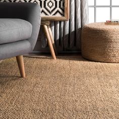 a chair and ottoman in a living room with a rug on the floor next to it