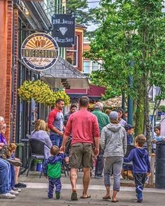 a group of people walking down a street next to tall buildings