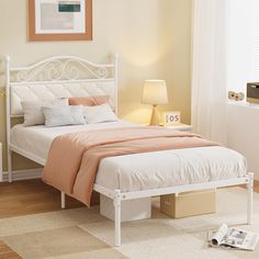 a white bed sitting in a bedroom on top of a hard wood floor