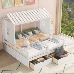 a dollhouse bed with drawers underneath it in a room that has pink walls and flooring