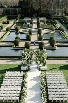 an outdoor ceremony setup with rows of white chairs and flowers on each side of the aisle