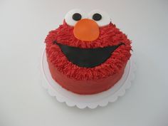 a red cake decorated with an elmo face