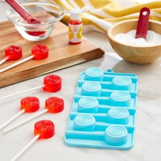 candy lollipops are lined up on a cutting board and ready to be eaten