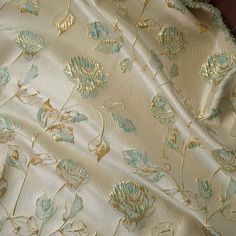 the fabric has gold and blue flowers on it