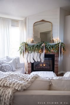 a living room decorated for christmas with stockings hanging from the mantel and lights on the mantle