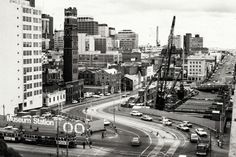 an aerial view of a busy city street with construction in the foreground and tall buildings on either side