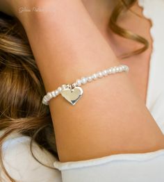 Fall in love all over again with this glimmering silver heart and pearl bracelet....................... White/ Ivory freshwater pearls are AA quality and measure about 2mm Shiny sterling heart measures about 13mm Chain is dainty 925 sterling silver Bracelet is adjustable (choose your size) Bracelet closes with a sterling silver spring clasp This is a handmade item and made for you after the order is placed PACKAGINGAll Jewelry is carefully packaged for a safe arrival and is secured in a jewelry