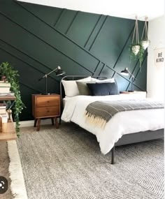 a bedroom with dark green walls and white bedding