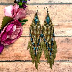 two pairs of beaded earrings with flowers on the side next to it and a pink flower