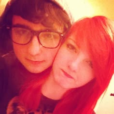 two people with red hair and glasses posing for the camera