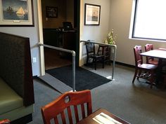 an empty restaurant with tables and chairs next to a door that leads into the dining room