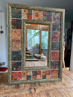 a mirror that is sitting on top of a wooden floor in front of a window