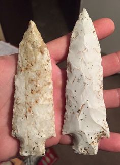 two pieces of white rock are held in someone's hand