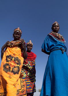 three women in brightly colored clothing standing next to each other