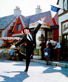 a man in a tuxedo is dancing on the street