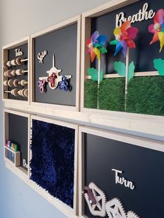 the wall is decorated with different types of paper flowers and windmills on them,