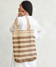 Natural Lao Vine Tote Natural Stripe This versatile and eco-friendly bag is perfect for beach days, grocery runs, and beyond. A completely natural product handcrafted from 100% kudzu vine fiber that grows wildly in northern Laos without any cultivation, irrigation or chemicals. Handcrafted from 100% kudzu vine fiber. Zero waste, organic, vegan, plastic-free, chemical-free, and Fair Trade. Due to the handmade nature of this bag, product may slightly vary as each one is unique. Please note that th Beige Fair Trade Crochet Beach Bag, Beige Crochet Beach Bag, Fair Trade, Beige Fair Trade Crochet Bag For Beach, Fair Trade Beige Crochet Bag For Beach, Fair Trade Jute Crochet Bag For Beach, Eco-friendly Handwoven Natural Crochet Bag, Fair Trade Natural Fiber Crochet Beach Bag, Natural Color Fair Trade Beach Bag, Fair Trade Crochet Bag For Daily Use