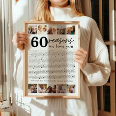 a woman holding up a framed poster that says 60 reasons we love you