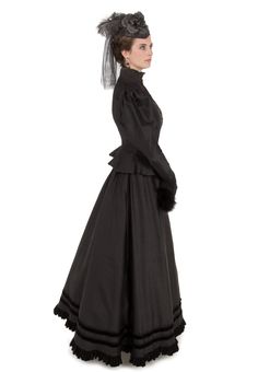 The traditional late-Victorian silhouette is accomplished beautifully with a closely-fitted bodice featuring a high neckline with a stand-up collar made of shirred black silk chiffon and trimmed in lace, with many small buttons closing the front. A gently ruffled peplum skims over the hips. Large poufed sleeves taper to lace-trimmed narrow cuffs, which have an additional black silk chiffon deep ruffle at the wrist. The hem of the matching skirt is finished with a black velvet ruffle, just below Long Sleeve Victorian Dress With Fitted Bodice, Black Historical Victorian Costume Dress, Historical Black Victorian Costume Dress, Black Regency Style Victorian Costume Dress, Black Victorian Dress Costume, Black Victorian Dress For Costume, Fitted Black Dress With Historical Design, Fitted Black Dresses With Historical Design, Black Historical Victorian Wedding Dress