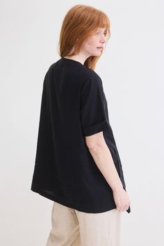 The relaxed fit and unique design elements offer both comfort and a fashion-forward statement, perfect for those who appreciate distinctive style. Made with Linen, it is breathable and effortlessly chic, offering a relaxed yet sophisticated look. Modern Tops With Shirttail Hem For Work, Black Asymmetrical Cotton Top, Modern Asymmetrical Hem Top For Fall, Versatile Summer Tunic With Relaxed Fit, Chic Oversized Tunic For Loungewear, Black Oversized Tunic For Spring, Oversized Black Tunic For Spring, Relaxed Fit Asymmetrical Tops For Layering, Oversized Casual Blouse With Curved Hem