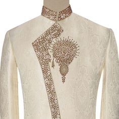 and Khussa This elegant off-white sherwani is the perfect attire for your wedding day. The angrakha style flatters a variety of body types, and the premium quality, self-textured fabric provides a luxurious look and feel. The sherwani is adorned with intricate golden and maroon traditional handwork, making it a truly special piece. Color: Off-white Style: Angrakha Material: Premium quality, self-textured fabric Embroidery: Golden and maroon traditional handwork Includes: Sherwani, Maroon Aitchis White Sherwani, Sherwani For Groom, Black Tuxedo Suit, Waistcoat Designs, Prince Coat, Sherwani Groom, Angrakha Style, Blue Tuxedos, Groom Shoes