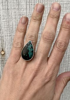 A lovely natural large teardrop Tibetan Turquoise has been set in sterling silver with a handmade ring band. This stone is lovely with an opaque black background and stunning bright turquoise blue veining. The ring band has been hand hammered as an accenting detail. The stone is 28mm x 18mm in size with a height of 6mm. Size 6.5, cannot be sized up or down. Turquoise is the birthstone for December! Sterling Silver Teardrop Rings, Bohemian Sterling Silver Turquoise Teardrop Ring, Sterling Silver Teardrop Rings With Natural Stones, Turquoise Teardrop Gemstone Rings, Teardrop Turquoise Sterling Silver Rings, Unique Turquoise Teardrop Rings, Unique Teardrop Turquoise Rings, Unique Teardrop Ring With Natural Stones, Handmade Turquoise Teardrop Ring Gift