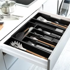 an open drawer with utensils in it