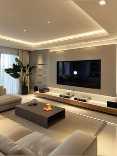 a living room with white couches and a large flat screen tv mounted on the wall