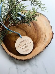 a wooden bowl with a tag that says, sleep by heaven peace on it and some branches