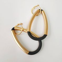 "A beautiful black and gold statement earrings. Elegant and sophisticated earrings that will upgrade any elegant outfit! Share with the world your exquisite taste! Available in silver plating as well. Lightweight earrings. * * * * * * * * * * * Materials: 24k gold plated brass - matte finish Silver plated brass - matte finish 0.20\"/5m\"m thick black silicon cord Measurements: Total length: 2.95\"/7.5 c\"m Width: 1.57\"/4 c\"m Hoop diameter: 0.79\"/2 c\"m Thickness: 0.24\"/6 m\"m * * * * * * * * Bold Black Drop Earrings, Chic Black Evening Earrings, Chic Black Metal Earrings, Modern Black Hoop Earrings For Party, Chic Black Hoop Earrings For Party, Chic Black Hoop Earrings, Silver Statement Necklace, Oversized Earrings, Silver Necklace Statement