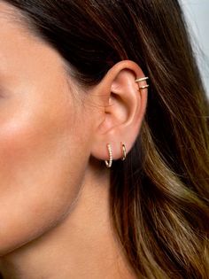 a close up of a person wearing an earring with two piercings on it