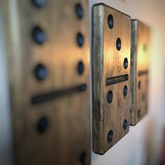 two metal pieces are hanging on the wall next to each other with holes in them