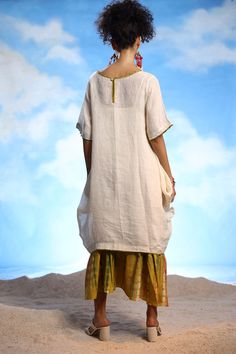 Ivory linen boho tunic dress with thread embroidery. Comes with a yellow cotton long frilled inner with tie-dye print.
Components: 2
Pattern: Printed, Embroidered
Type Of Work: Tie-Dye, Thread
Neckline: Round
Sleeve Type: Dress : Half, Inner : Sleeveless
Fabric: Dress : Linen, Inner : Cotton
Color: Ivory, Yellow
Other Details: 
Closure : Back button
Note : Earrings worn by the model are not for sale.
Occasion: Work - Aza Fashions White Bohemian Linen Dress Made Of Ramie, White Bohemian Ramie Linen Dress, Peasant Linen Tunic Dress, Bohemian Linen Tunic Dress, White Linen Peasant Dress, White Bohemian Dress With Natural Dye, Beige Bohemian Linen Dress, Traditional White Linen Dress, Bohemian Tunic Linen Dress