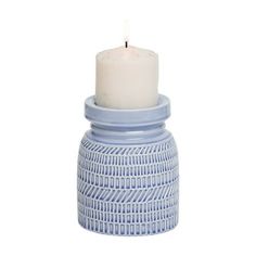 a blue and white ceramic candle holder with a lit candle in the middle on a white background