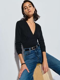 We heard you were looking for that simple, elegant staple that goes with everything. This top features pleats at the bodice and bust, waist panels, and a V-neckline. Simple, yet elegant. (This one comes in Jet Black.) | Andy Top in Jet Black | Ethical Essentials Versatile Fitted Wrap Top For Workwear, Chic Fitted Wrap Top For Work, Stretch Wrap Top For Work, Spring Workwear Fitted Wrap Top, Classic Spring Tops For Date Night, Classic Tops For Date Night In Spring, Classic Long Sleeve Tops For Date Night, Versatile Fitted Wrap Top For Night Out, Effortless Long Sleeve Fitted Tops