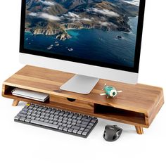 a computer monitor sitting on top of a wooden desk next to a keyboard and mouse