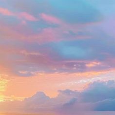 the sun is setting over the ocean with clouds in the sky, and two surfers are standing on the beach