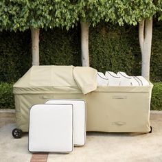 an outdoor furniture set up in front of some trees