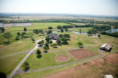 an aerial view of a baseball field in the middle of a rural area with lots of trees