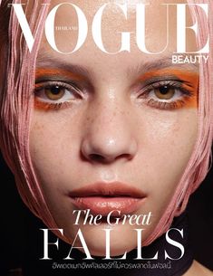 a woman with pink hair and orange makeup on the cover of a magazine, featuring an image of her face