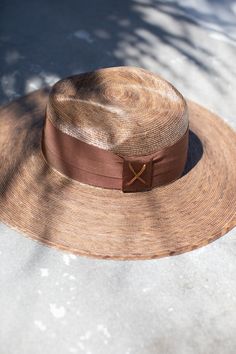 The most beautiful straw panama we've ever carried!! The glamorous Riviera hat is the perfect straw hat to offer full sun protection. Its body is braided by artisan hands and interlaced with palm leaves to create the finished design. Hat has a sealer on it making it water resistant. The construction of this hat is incredible. It’s completed with a rustic cotton braided trim. Features an inner elastic band for a OSFM fit! 100% Palm leaf, natural color (One Size) Standard Medium 58 cm Crown 4” Bri Luxury Straw Hat With Short Brim For Beach, Luxury Short Brim Straw Hat For Beach, Luxury Fedora Straw Hat For Beach, Luxury Short Brim Straw Hat For The Beach, Luxury Fedora Straw Hat For The Beach, Luxury Wide Brim Boater Hat For Summer, Luxury Summer Sun Hat, Luxury Curved Brim Sun Hat For Beach, Luxury Brimmed Boater Hat For Summer