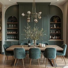 an elegant dining room with green walls and wooden flooring, surrounded by built - in bookshelves