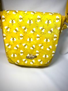 "Crossbody saddle bag. Perfect casual design in a stunning - fun design. Approximately 9\" wide, 9.5\" tall, and 3.75\" deep! Because each bag is made by hand, approximate dimensions may vary slightly. Smaller size, but lots of room for your belongings. Lots of pockets! Front features large slip pocket when flap is lifted. Interior slip pocket and interior zipper pocket for extra security.  Bee turn lock!  Luxurious and bright yellow faux leather and cotton! Interior is yellow with white polka dots and is 100% cotton!" Cute Yellow Crossbody Bag, Cute Yellow Bag With Adjustable Strap, Cute Yellow Bags With Adjustable Strap, Yellow Rectangular Satchel With Detachable Strap, Yellow Crossbody Bag With Cell Phone Pocket, Yellow Shoulder Bag With Cell Phone Pocket, Cute Yellow Satchel Shoulder Bag, Cute Rectangular Bag With Cell Phone Pocket, Cute Yellow Satchel Bag