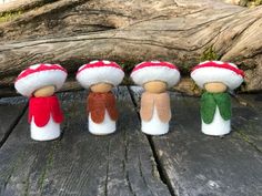 four small mushrooms sitting on top of a wooden table